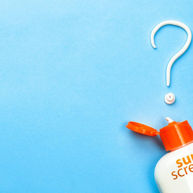 Sunscreen. Cream in the form of question mark on blue background with white tube. Concept of how to choose sunblock.