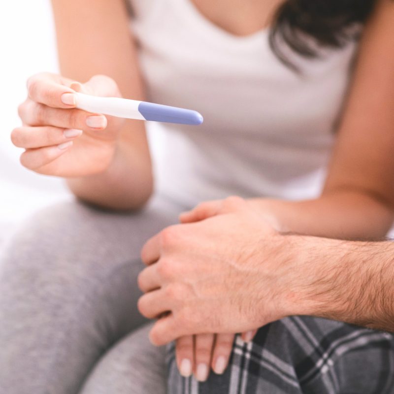 Decisive moment. Worried man and woman waiting for result of pregnancy test, close up